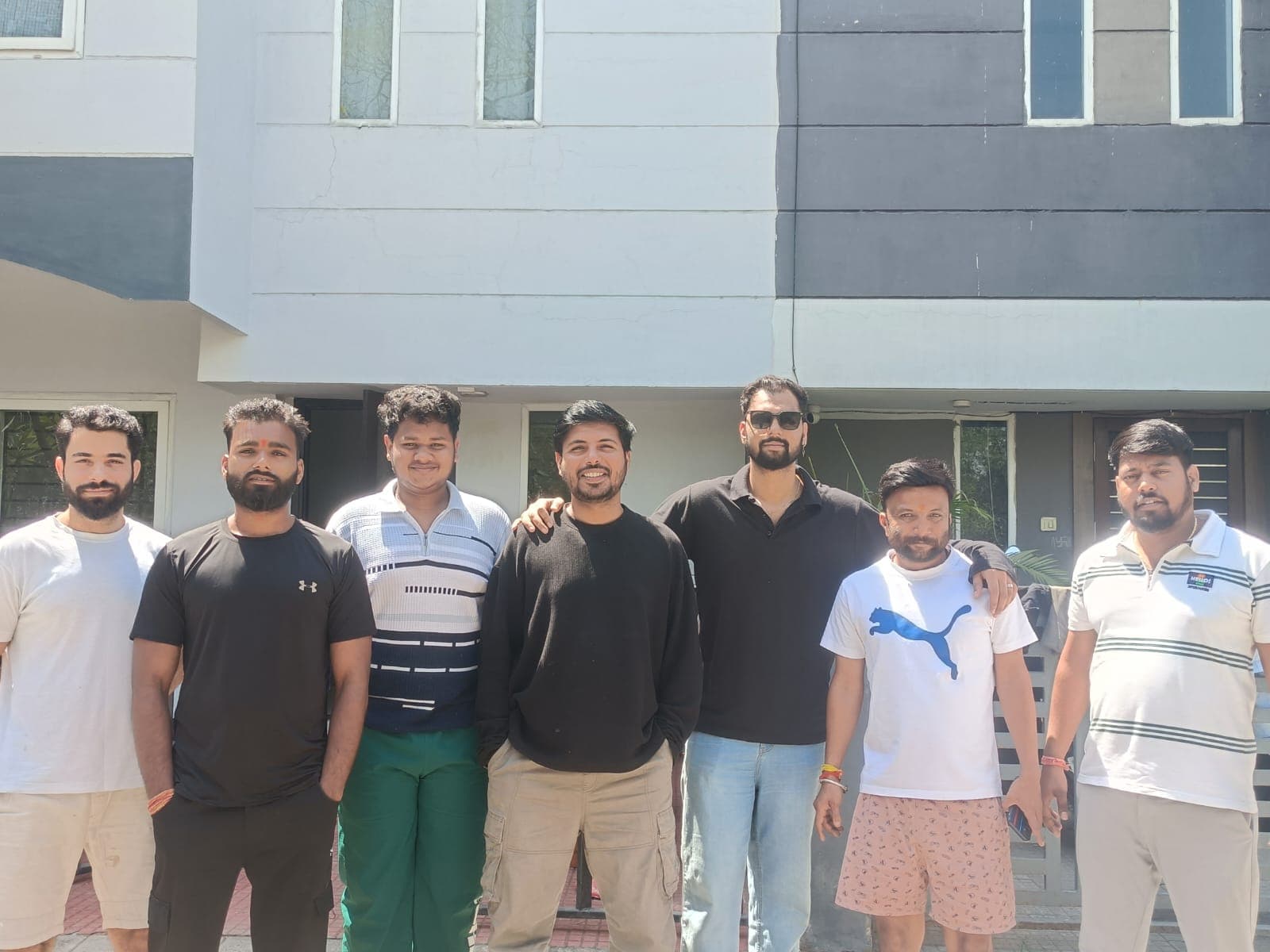 Seven people standing together outdoors